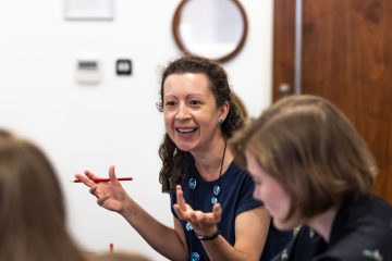 A happy adult female expressing herself at a training course event