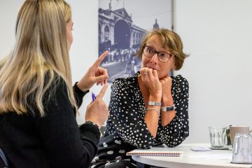 Two adult females in discussion at a training course event