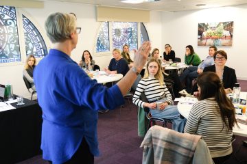 Training facilitator talking to a group of training course attendees